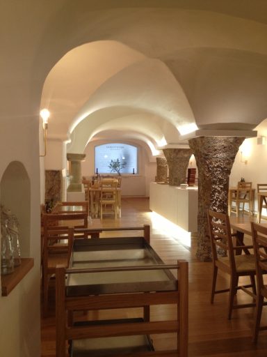 Gastronomischer Innenraum mit Holzmöbeln und gewölbten Decken.